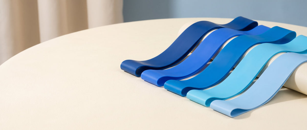 Gradient blue resistance bands on a pale cream surface.
